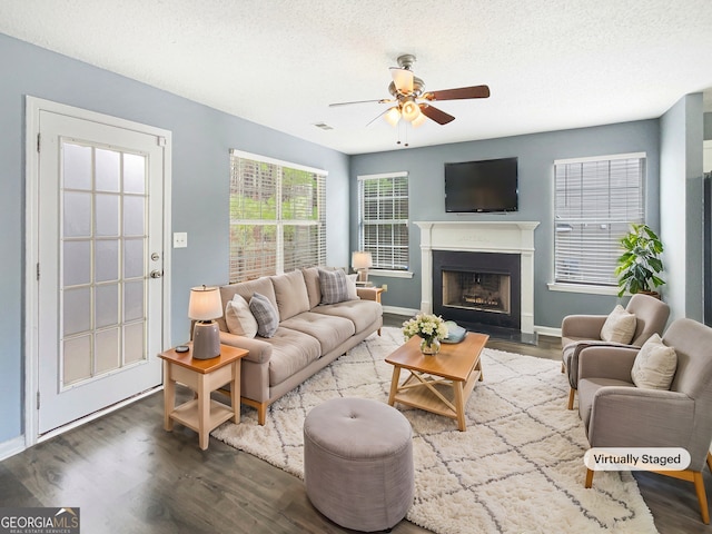 living room with hardwood / wood-style flooring, ceiling fan, and a textured ceiling