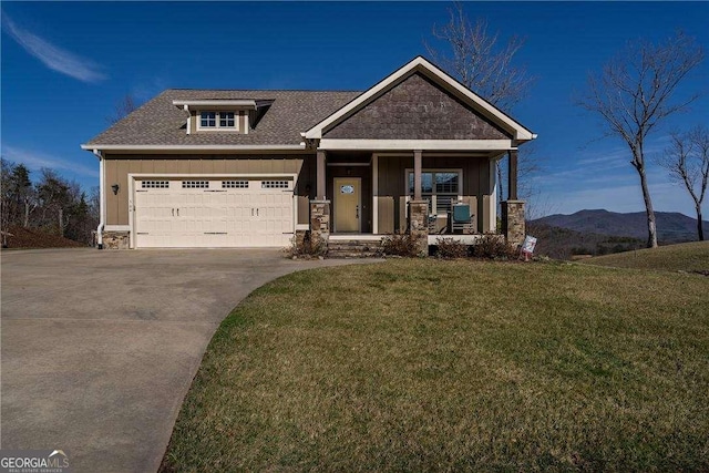 craftsman-style house with a garage, a mountain view, a front yard, and covered porch