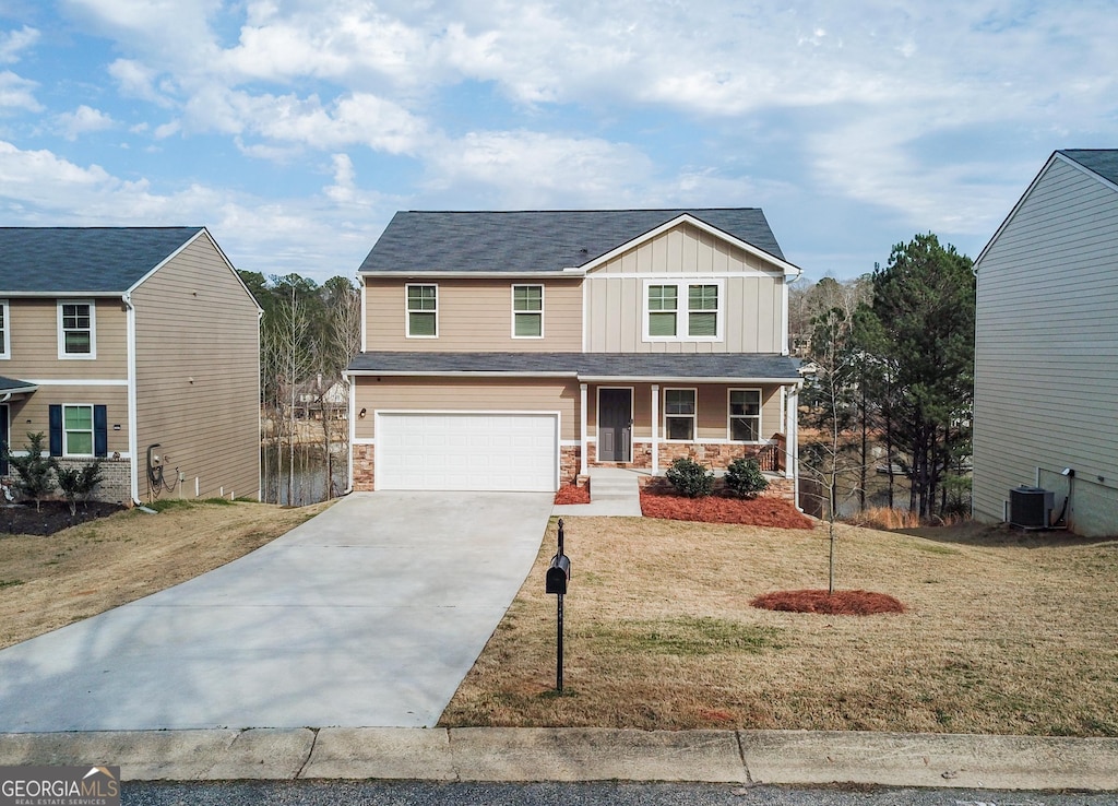 view of front of property featuring a garage, central AC unit, covered porch, and a front yard