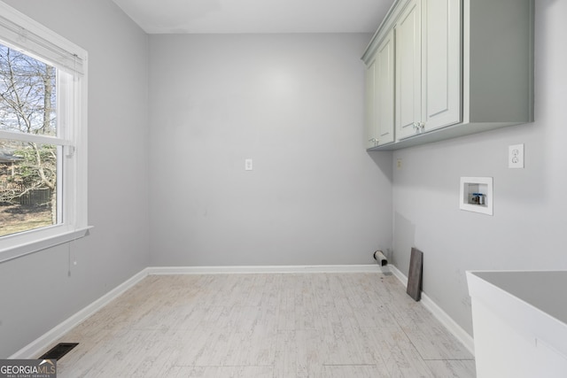 laundry room featuring washer hookup, cabinet space, visible vents, and baseboards