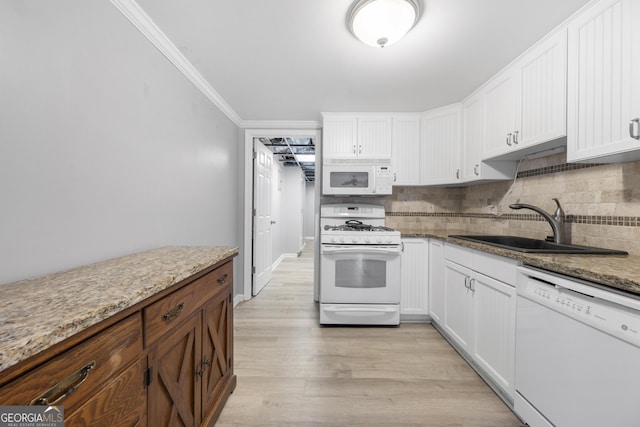 kitchen featuring light stone counters, white appliances, a sink, and white cabinetry