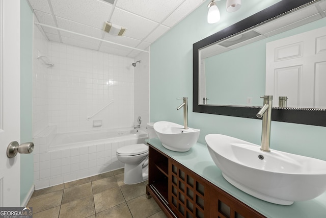 bathroom featuring a sink, tiled shower / bath combo, toilet, and double vanity