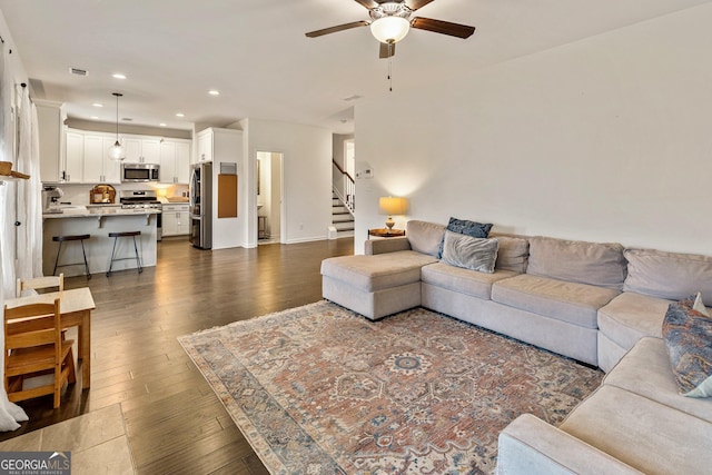 living area with dark wood finished floors, recessed lighting, visible vents, a ceiling fan, and stairs