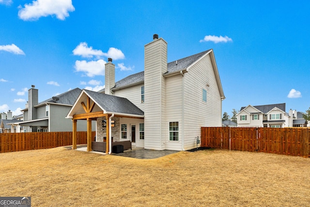 rear view of house with a shingled roof, a residential view, a fenced backyard, and a patio