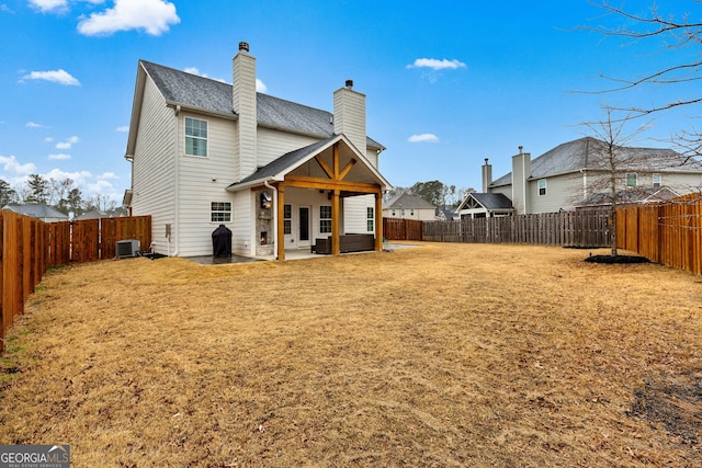 rear view of property featuring a patio, a yard, cooling unit, and a fenced backyard