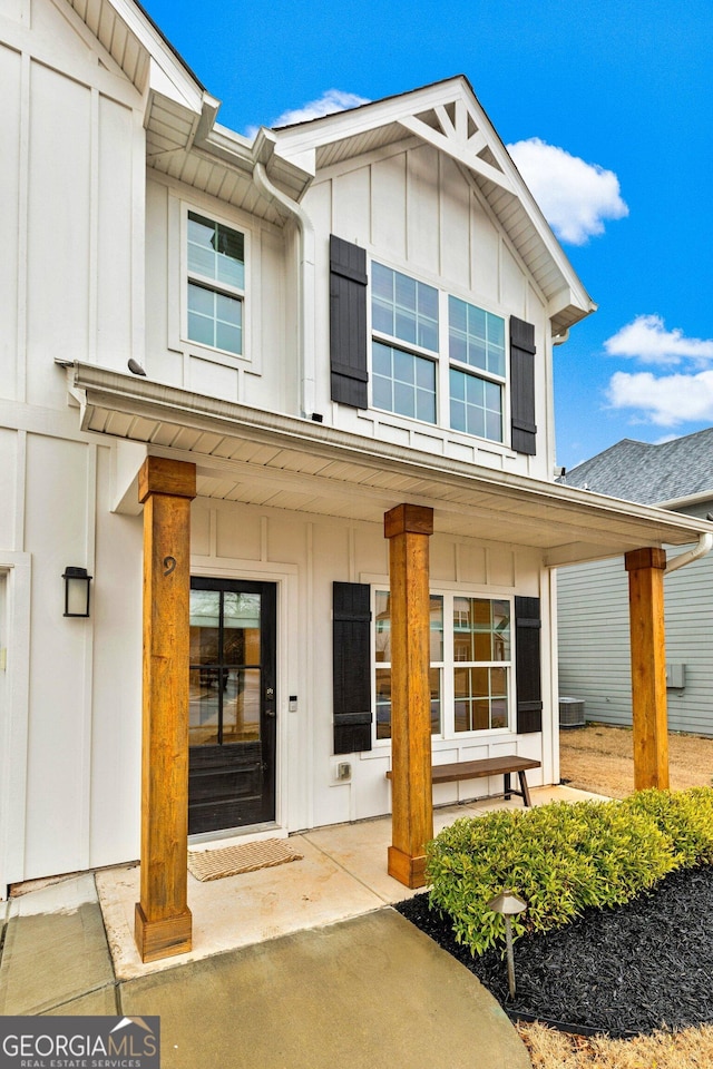 view of front of house featuring board and batten siding, a porch, and central air condition unit