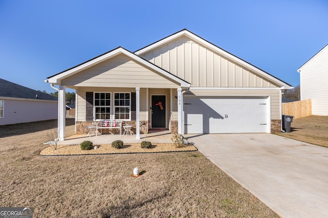 view of front of property featuring a garage, a front lawn, and a porch