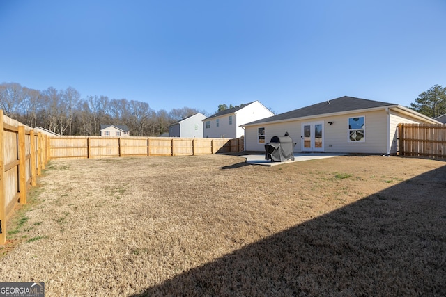 rear view of property featuring a patio, a yard, and french doors