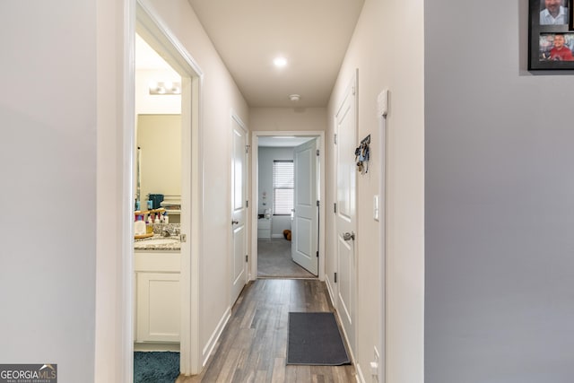 corridor with sink and light hardwood / wood-style flooring