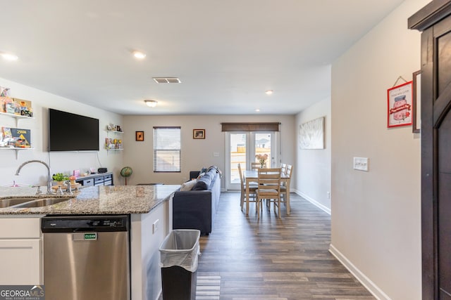 kitchen featuring sink, white cabinetry, light stone counters, stainless steel dishwasher, and dark hardwood / wood-style floors