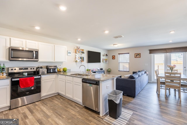 kitchen featuring appliances with stainless steel finishes, kitchen peninsula, sink, and white cabinets