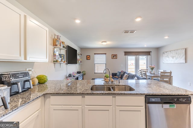 kitchen with sink, stone countertops, stainless steel dishwasher, kitchen peninsula, and white cabinets