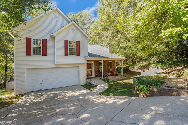 tri-level home with a garage, brick siding, driveway, and a chimney