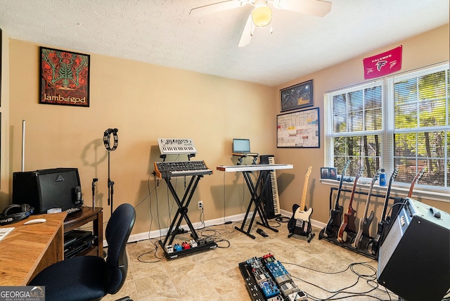 office space with a textured ceiling, a ceiling fan, and baseboards