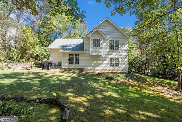 rear view of property featuring roof with shingles, a lawn, and a patio