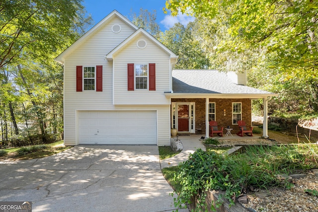 tri-level home with driveway, a porch, roof with shingles, an attached garage, and a chimney