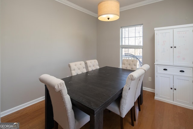 dining area with crown molding and light hardwood / wood-style flooring