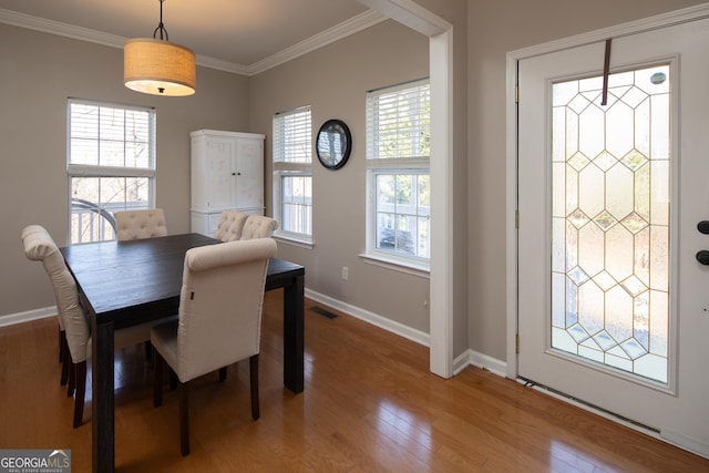 dining room with ornamental molding and hardwood / wood-style floors