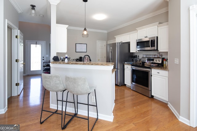 kitchen featuring kitchen peninsula, stone counters, stainless steel appliances, light hardwood / wood-style floors, and white cabinets