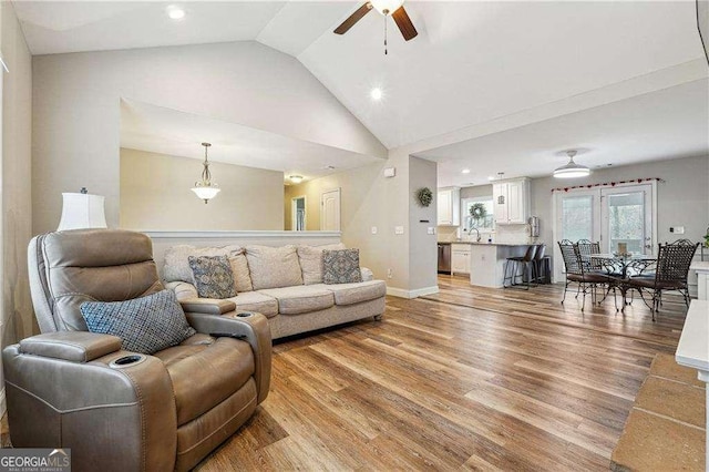 living room featuring ceiling fan, high vaulted ceiling, sink, and light hardwood / wood-style flooring