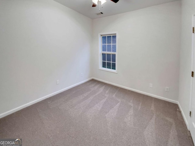 carpeted spare room featuring ceiling fan