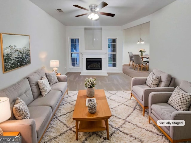 living room featuring ceiling fan with notable chandelier