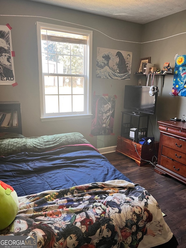 bedroom with a textured ceiling and wood finished floors