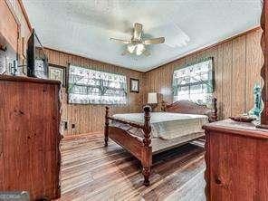 bedroom featuring wooden walls and wood finished floors