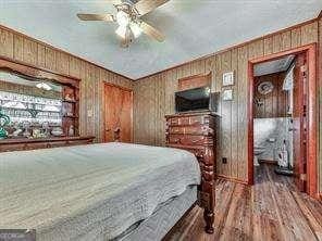 bedroom with wooden walls and wood finished floors