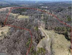 birds eye view of property featuring a forest view