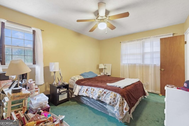 bedroom featuring ceiling fan and dark colored carpet