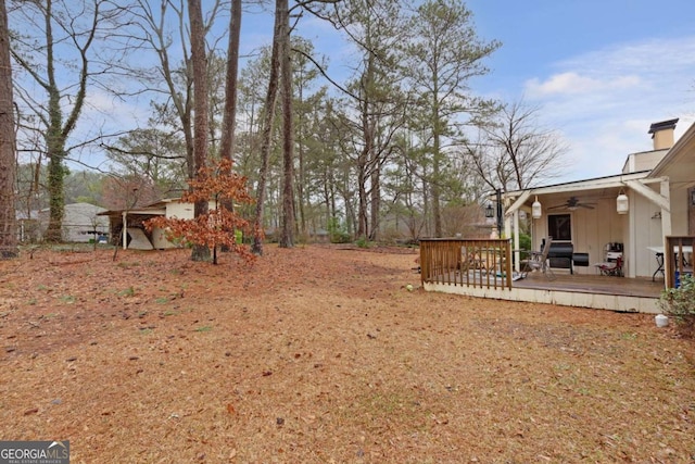 view of yard with a wooden deck and ceiling fan