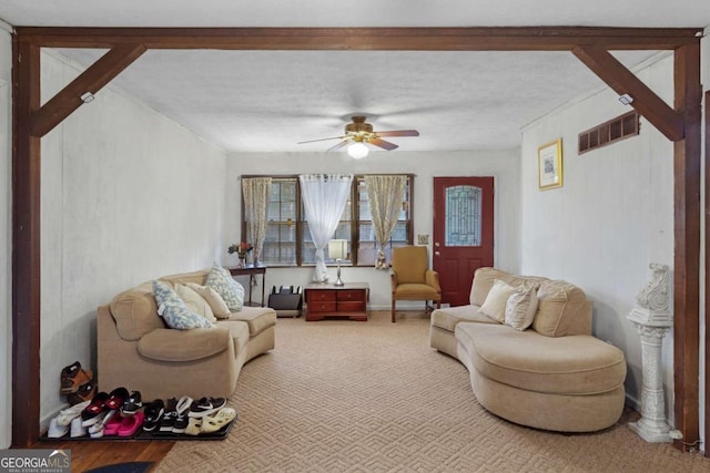 carpeted living room with ceiling fan and a textured ceiling