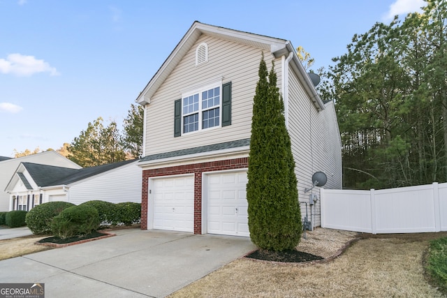 view of home's exterior with a garage, concrete driveway, brick siding, and fence