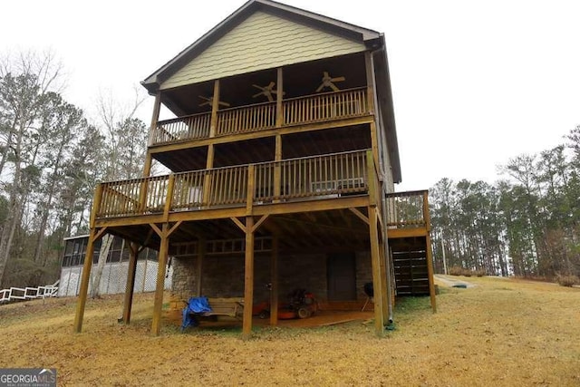 back of house with a wooden deck and ceiling fan