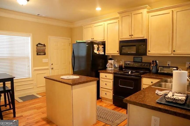 kitchen featuring crown molding, black appliances, a center island, light hardwood / wood-style floors, and white cabinets