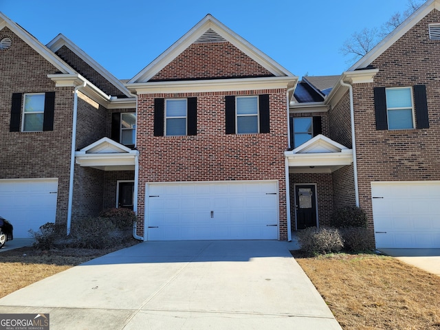 traditional-style home featuring driveway, an attached garage, and brick siding