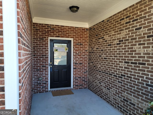 doorway to property featuring brick siding