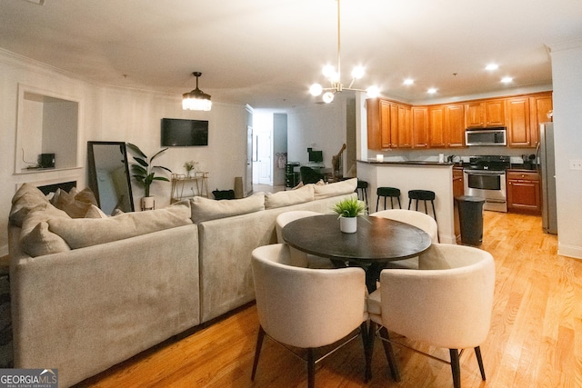 dining room featuring crown molding, an inviting chandelier, and light hardwood / wood-style floors