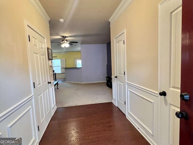 hall with dark wood-type flooring and ornamental molding