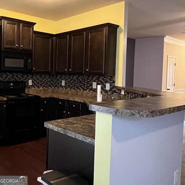 kitchen with a breakfast bar, black appliances, decorative backsplash, kitchen peninsula, and dark wood-type flooring