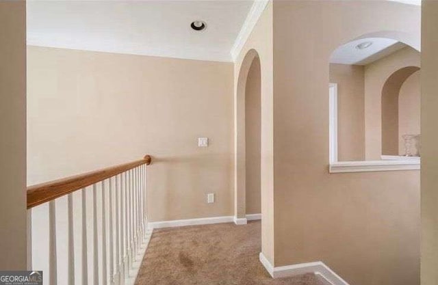 corridor with crown molding and light colored carpet