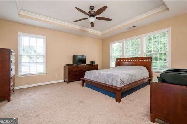 bedroom featuring ceiling fan, ornamental molding, a raised ceiling, and light carpet