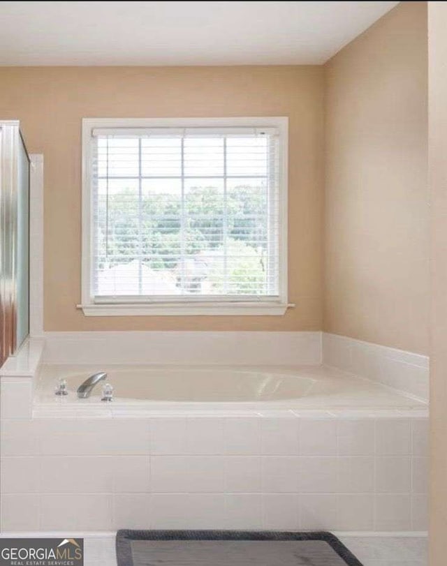 bathroom featuring a relaxing tiled tub