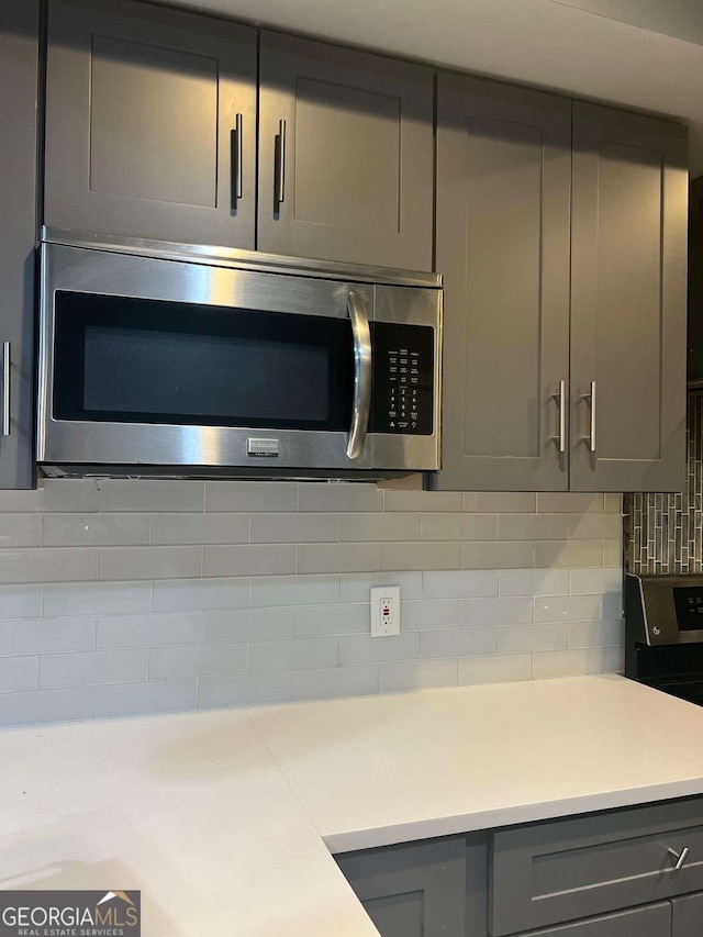 kitchen featuring gray cabinets, tasteful backsplash, and black range with electric cooktop