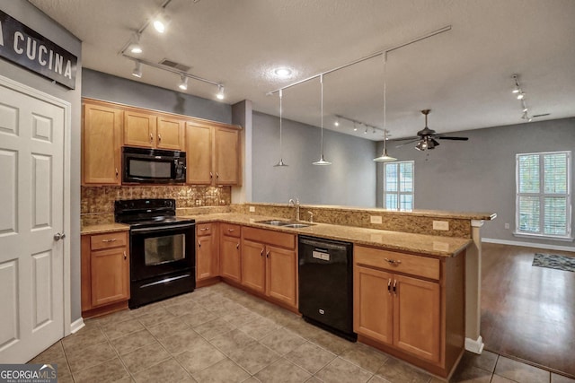 kitchen with pendant lighting, sink, black appliances, a healthy amount of sunlight, and kitchen peninsula