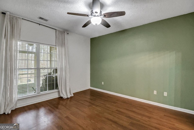 spare room with dark wood-type flooring, ceiling fan, and a textured ceiling