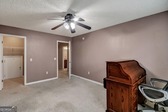 unfurnished office featuring ceiling fan, light carpet, and a textured ceiling