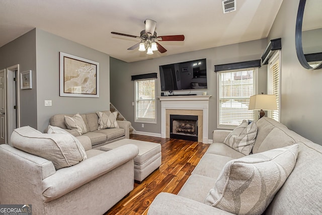 living room with a healthy amount of sunlight, dark wood-type flooring, and ceiling fan