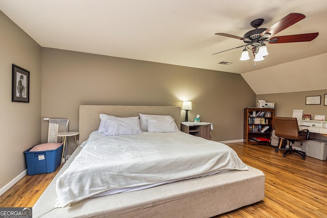 bedroom featuring hardwood / wood-style floors, vaulted ceiling, and ceiling fan